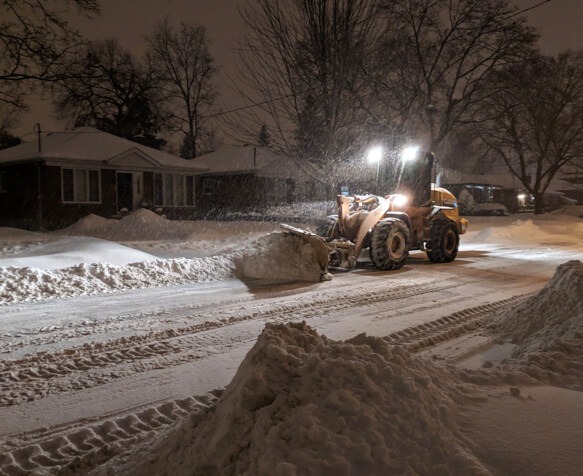 late night windrow snow removal done by a tractor snow plow